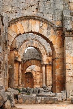 an arch in the side of a building that has stone walls and arches on it