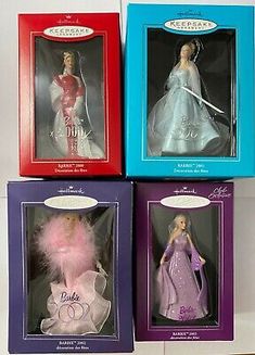 four barbie dolls in boxes on display