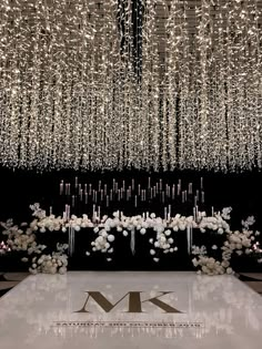 a large chandelier hanging from the ceiling above a table with flowers and candles