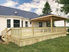 a white house with a blue roof and wooden steps leading up to the front porch