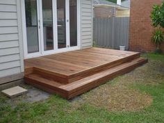 a wooden deck sitting in the middle of a yard