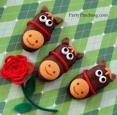 three decorated cookies with eyes, nose and mouth on top of a green checkered tablecloth