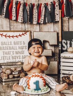 a baby sitting in front of a baseball themed cake