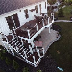 an aerial view of a white house with deck and railings in the front yard