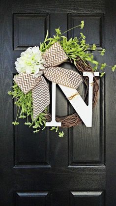 a black door with a wreath on it and the letter n in front of it