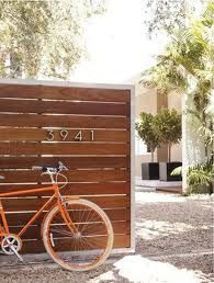 an orange bike is parked in front of a wooden wall with the word love written on it