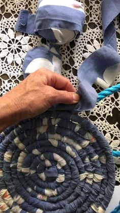 someone is making a woven basket with blue and white yarn on the tablecloths