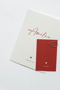 two red and white greeting cards with the word amelie on them are laying next to each other