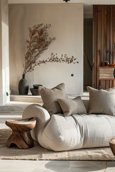 a living room filled with lots of furniture next to a wall mounted vase and painting