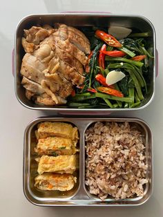 two metal containers filled with food on top of a white countertop next to each other