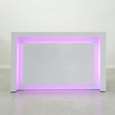 a white table with purple lights on it and a mirror in the middle that is lit up