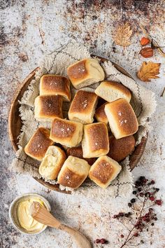 a bowl filled with bread on top of a table next to a jar of butter