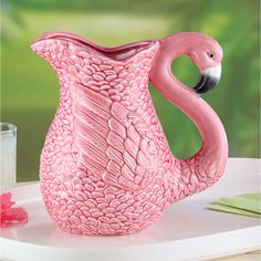 a pink flamingo shaped vase sitting on top of a table