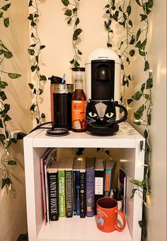 a shelf with books, coffee mugs and other items sitting on top of it