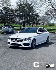 a white mercedes c - class parked in a parking lot