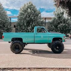 a blue pick up truck parked in a parking lot