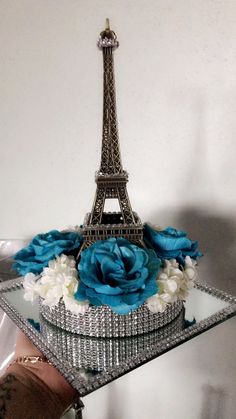 the eiffel tower is made out of glass and has blue flowers in it