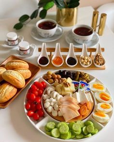 an assortment of food is displayed on a plate with dipping sauces and spoons