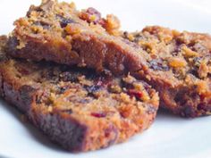 two pieces of fruitcake on a white plate