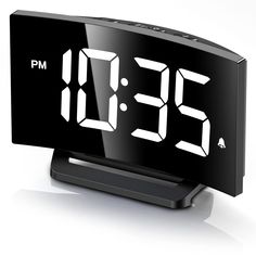 the alarm clock is black and has white numbers