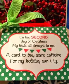 someone is holding up a christmas card in front of a potted plant with berries on it