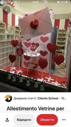 the window display for valentine's day is decorated with red hearts and paper umbrellas