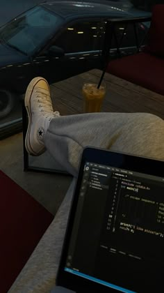 a person sitting on a couch with their feet up in front of a laptop computer