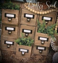 several wooden boxes with plants in them sitting on a table next to a clock and other items