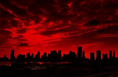 a red sky with clouds over a city