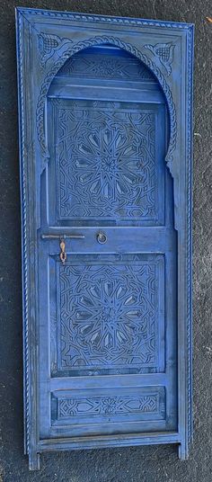 an ornate blue door on the side of a building