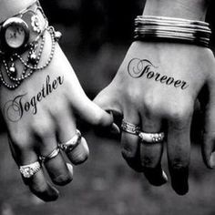 two hands that have tattoos on them and the words together written in cursive writing