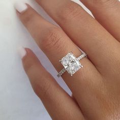 a woman's hand with a diamond ring on it and the engagement band around her finger