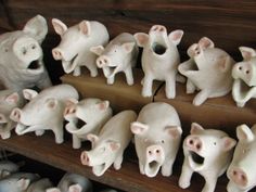 several ceramic pig figurines sitting on top of a shelf