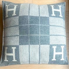 a gray and white checkered pillow sitting on top of a wooden floor