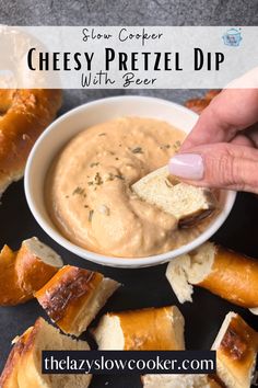 a hand dipping cheese pretzel dip into a bowl with bread on the side