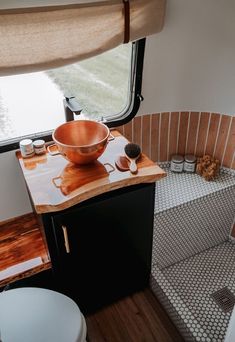 a bowl is sitting on top of a counter next to a toilet in a bathroom