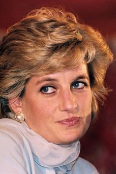 a close up of a person wearing a white shirt and tie with hair in the wind