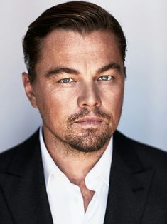 a close up of a person in a suit and tie looking at the camera with a serious look on his face