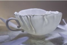 a white coffee cup sitting on top of a table next to some paper streamers