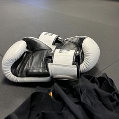 a pair of black and white boxing gloves laying on the ground