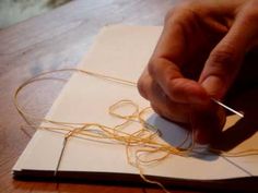 a person is working on some type of art project with scissors and string attached to the paper