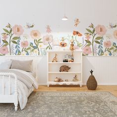 a bedroom with flowers painted on the wall and a white bed in front of it