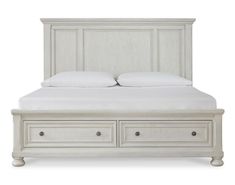 a white bed with two drawers underneath the headboard and pillows on top of it