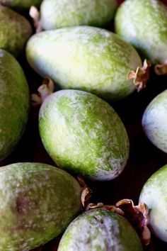 some green fruit sitting on top of a wooden table