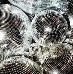 many shiny disco balls are piled up together