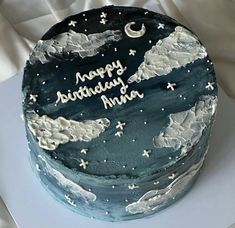 a birthday cake decorated with clouds and the words happy birthday india on it's side