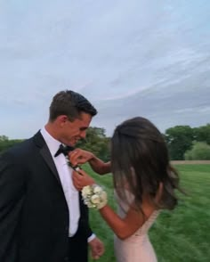 a bride and groom are standing in the grass