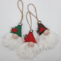 three christmas decorations hanging from twine with bells