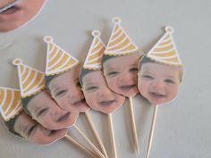 a group of cake toppers that have pictures of babies on them with party hats