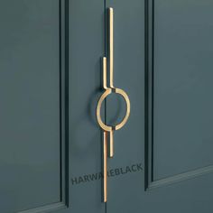 a door handle on the side of a green door with a circular design in gold